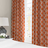 Curtains made from a printed linen fabric sample in blue and orange featuring a stylized fern pattern.