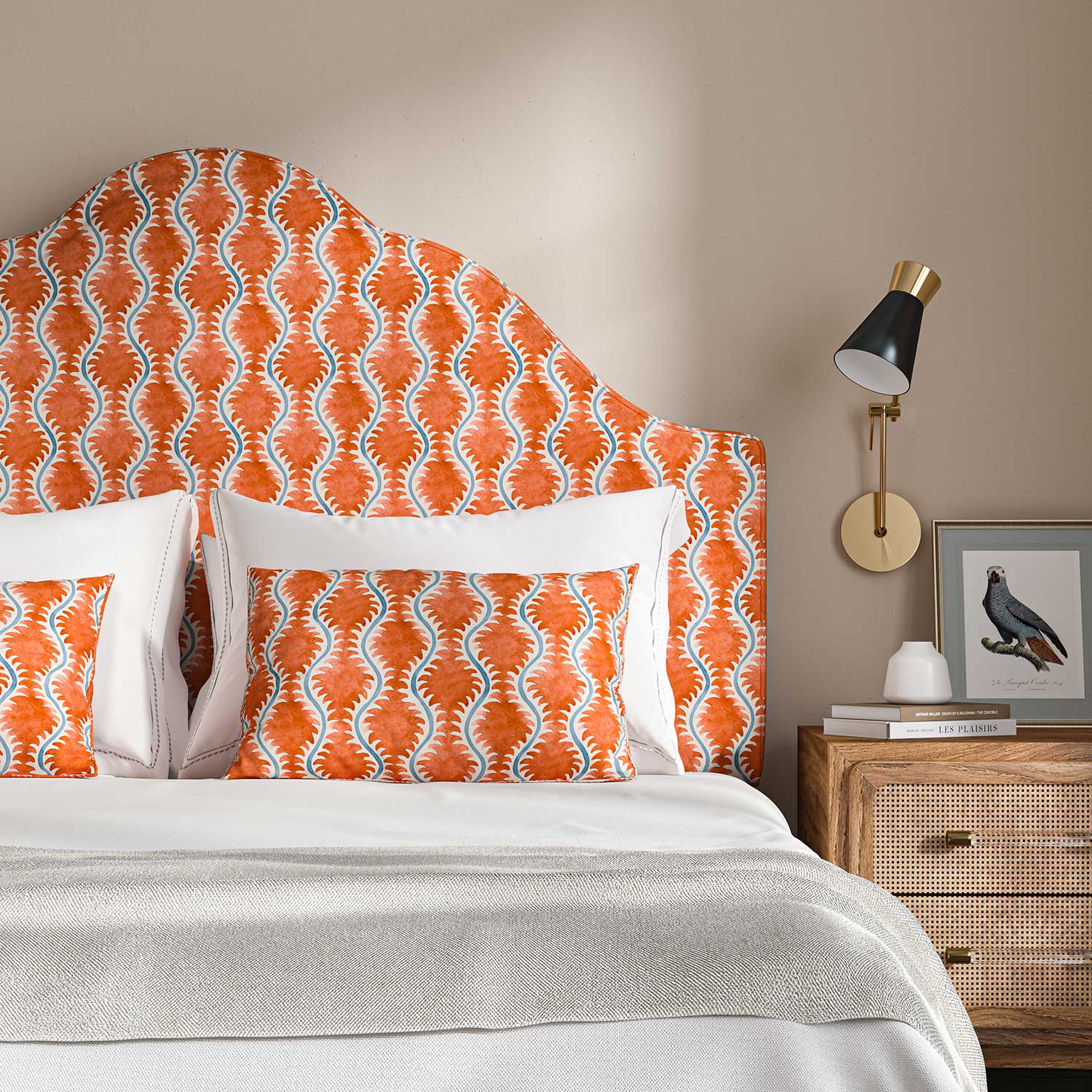 Headboard upholstered in a printed linen fabric sample in blue and orange featuring a stylized fern pattern.