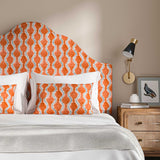 Headboard upholstered in a printed linen fabric sample in blue and orange featuring a stylized fern pattern.