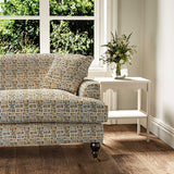 Sofa upholstered in a printed linen fabric in black, orange and off white featuring a basketweave pattern.