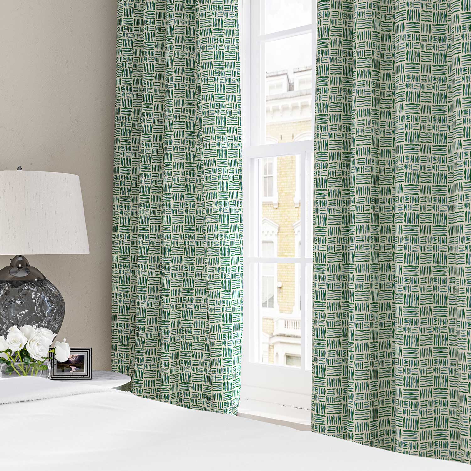 Curtains made from a printed linen fabric in blue, green and off white featuring a basketweave pattern.