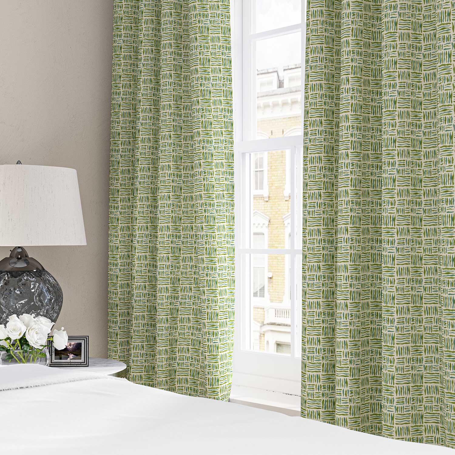 Curtains made from a printed linen fabric in green, blue and off white featuring a basketweave pattern.