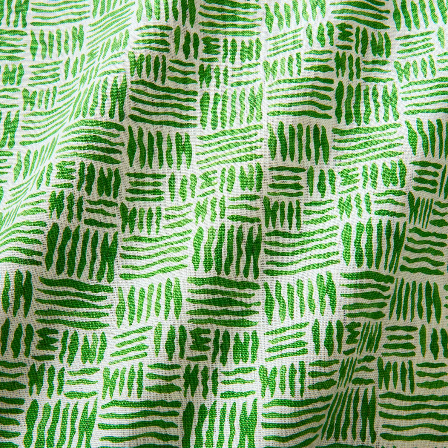 A printed linen fabric sample in green and off white featuring a basketweave pattern.