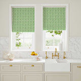 Blinds made from a printed linen fabric in green and off white featuring a basketweave pattern.