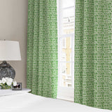 Curtains made from a printed linen fabric in green and off white featuring a basketweave pattern.