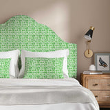 Headboard upholstered in a printed linen fabric in green and off white featuring a basketweave pattern.