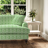 Sofa upholstered in a printed linen fabric in green and off white featuring a basketweave pattern.