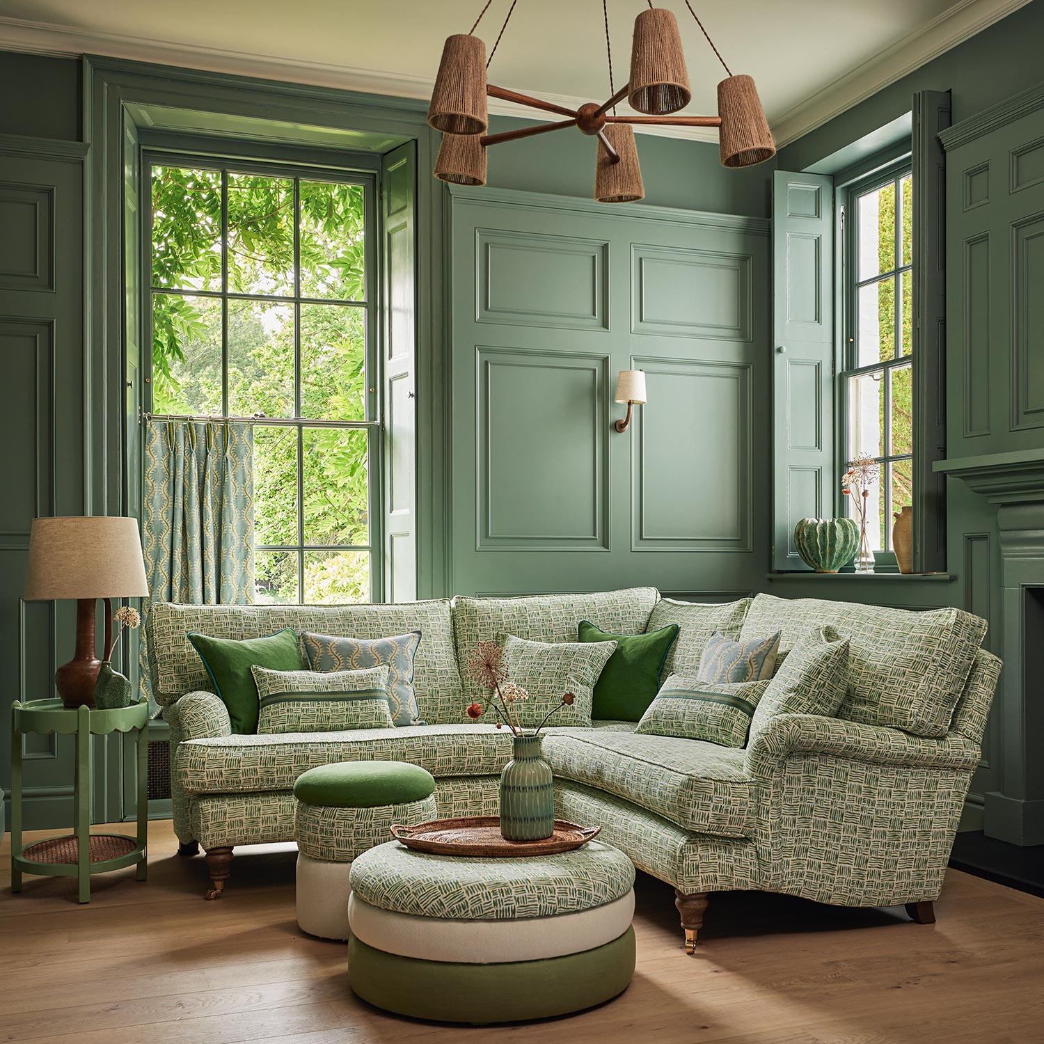 Sofa upholstered in a printed linen fabric in green, blue and off white featuring a basketweave pattern.