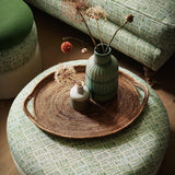 Footstool upholstered in a printed linen fabric in green, blue and off white featuring a basketweave pattern.