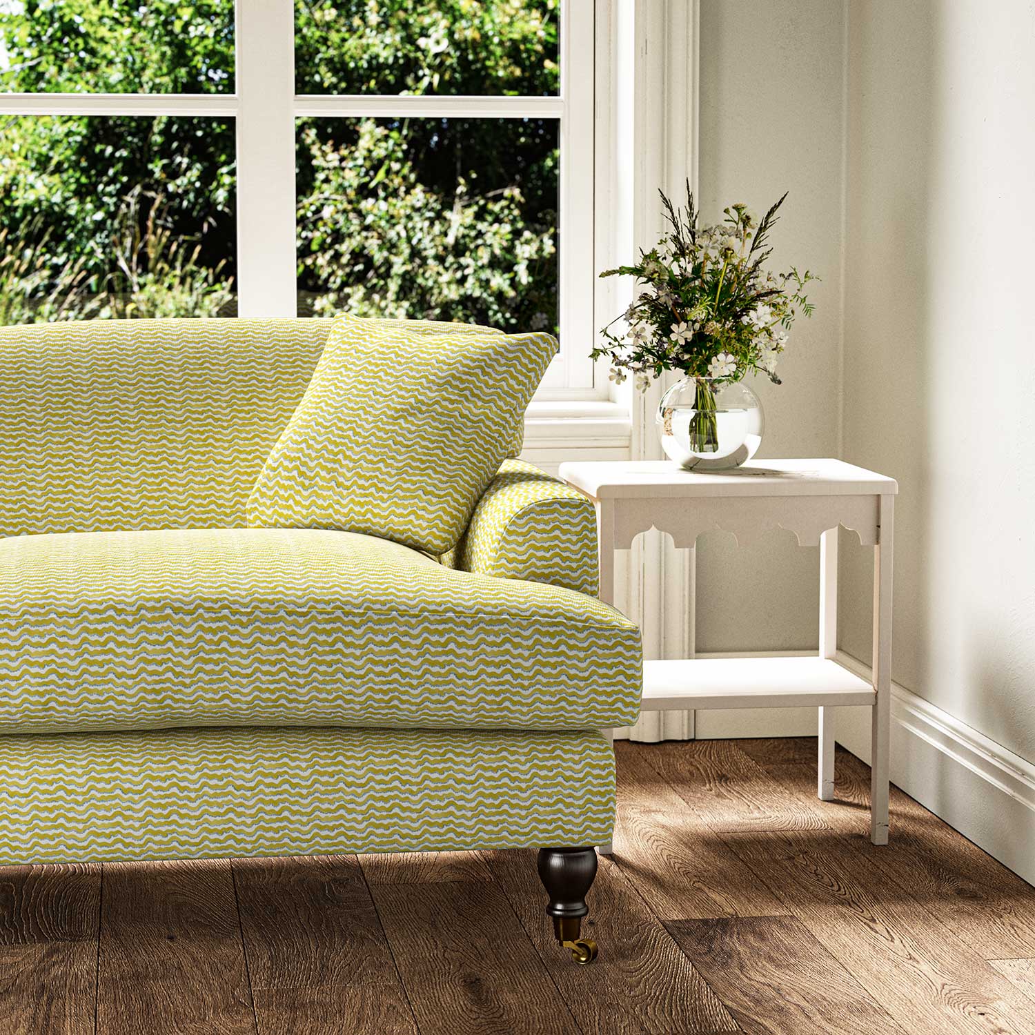 Sofa upholstered in a printed linen fabric sample in yellow, blue and off white featuring a sound wave pattern