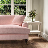 Sofa upholstered in a printed linen fabric sample in pink, red and off white featuring a sound wave pattern