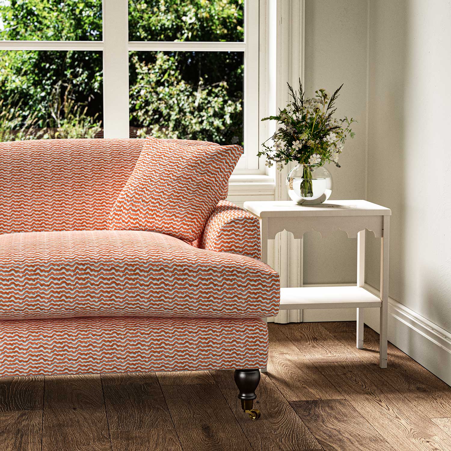 Sofa upholstered in printed linen fabric sample in a red, blue and off white featuring a sound wave pattern