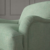 Green chair upholstered in a chenille woven fabric.