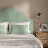 Green headboard upholstered in a chenille woven fabric.