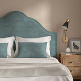 Blue headboard upholstered in a chenille woven fabric.