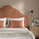 Orange headboard upholstered in a chenille woven fabric.