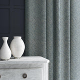 Curtain in blue and off-white woven fabric featuring a herringbone pattern.