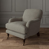Chair upholstered in a blue and off-white woven fabric featuring a trellis pattern.