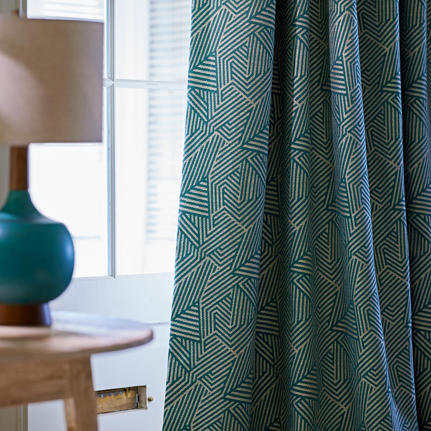Curtain in a blue and off-white woven fabric featuring a geometric pattern.