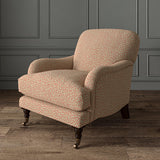 Chair upholstered in a pink and off-white woven fabric featuring a wavy pattern.