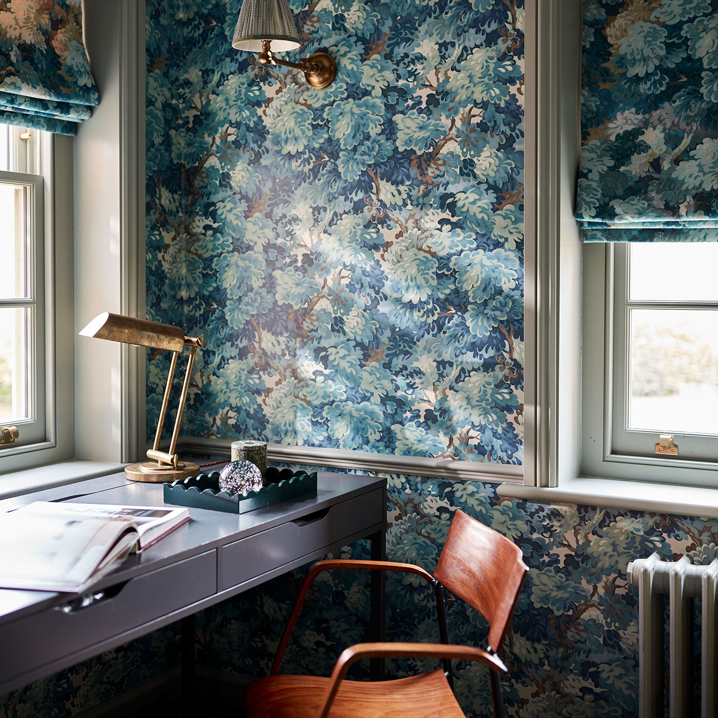 Inspired by an 18th-century garden tapestry, this blue wallpaper features the timeless beauty of English Oak canopies