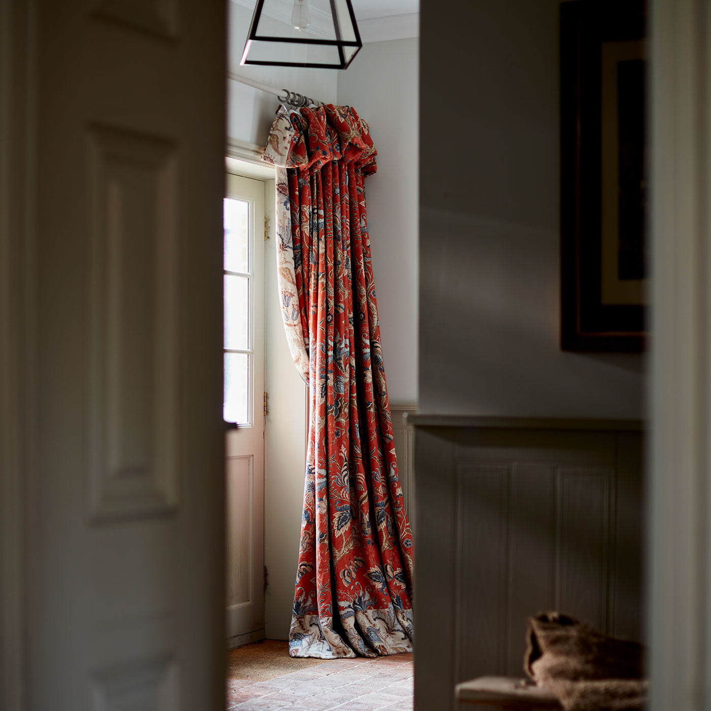Curtains with a orange fabric with a stylised floral design