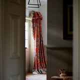 Curtains with a orange fabric with a stylised floral design