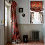 Curtains with a orange fabric with a stylised floral design