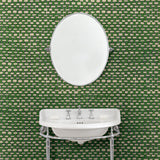 Cloakroom featuring green wallpaper with faux basketweave pattern