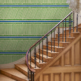 Hall with a playful green and blue wallpaper with a combination of tonal stripes, zigzags, and matching colour bands.