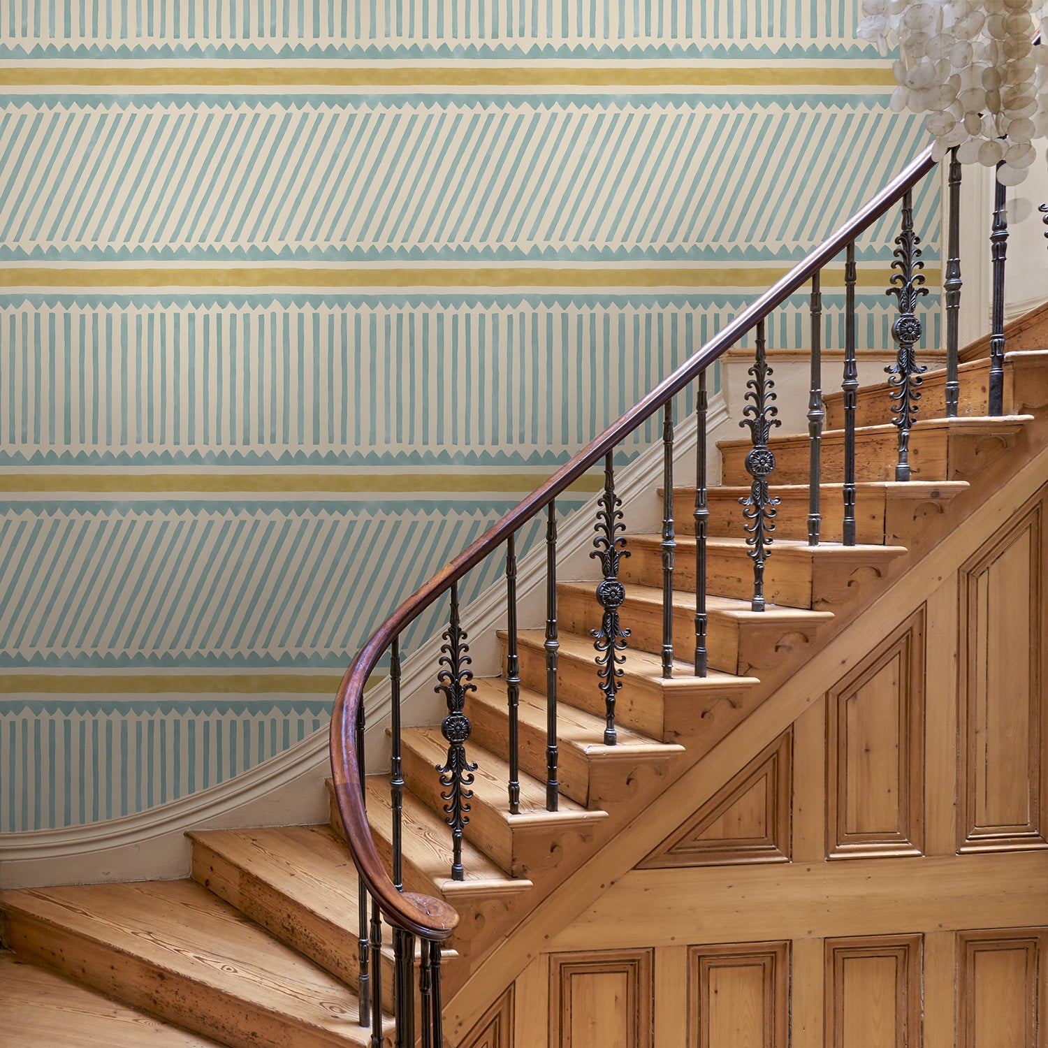Hall with a blue and yellow wallpaper with a combination of tonal stripes, zigzags, and matching colour bands.