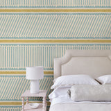 Bedroom with a blue and yellow wallpaper with a combination of tonal stripes, zigzags, and matching colour bands.