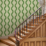 Luxurious wallpaper featuring stylised ferns and wavy lines in green and cream.