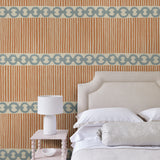 Bedroom with a chain-link wallpaper with different-sized blue and brown stripes.