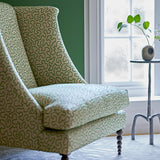 Chair upholstered in a green and off-white woven fabric featuring a wavy pattern.