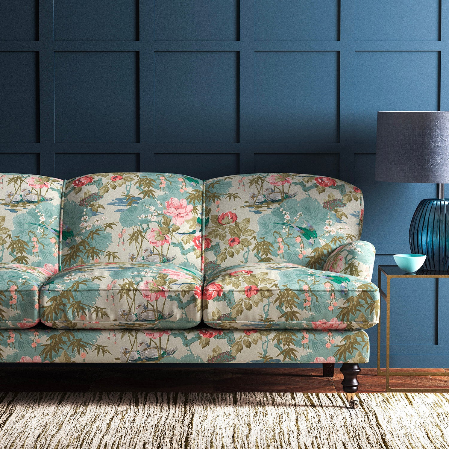 Sofa upholstered in an ivory and pink velvet upholstery fabric with a floral and bird design with a stain resistant finish.