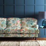 Sofa upholstered in an ivory and pink velvet upholstery fabric with a floral and bird design with a stain resistant finish.