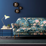 Sofa upholstered in a blue-coloured velvet upholstery fabric with a floral and bird design with a stain resistant finish.