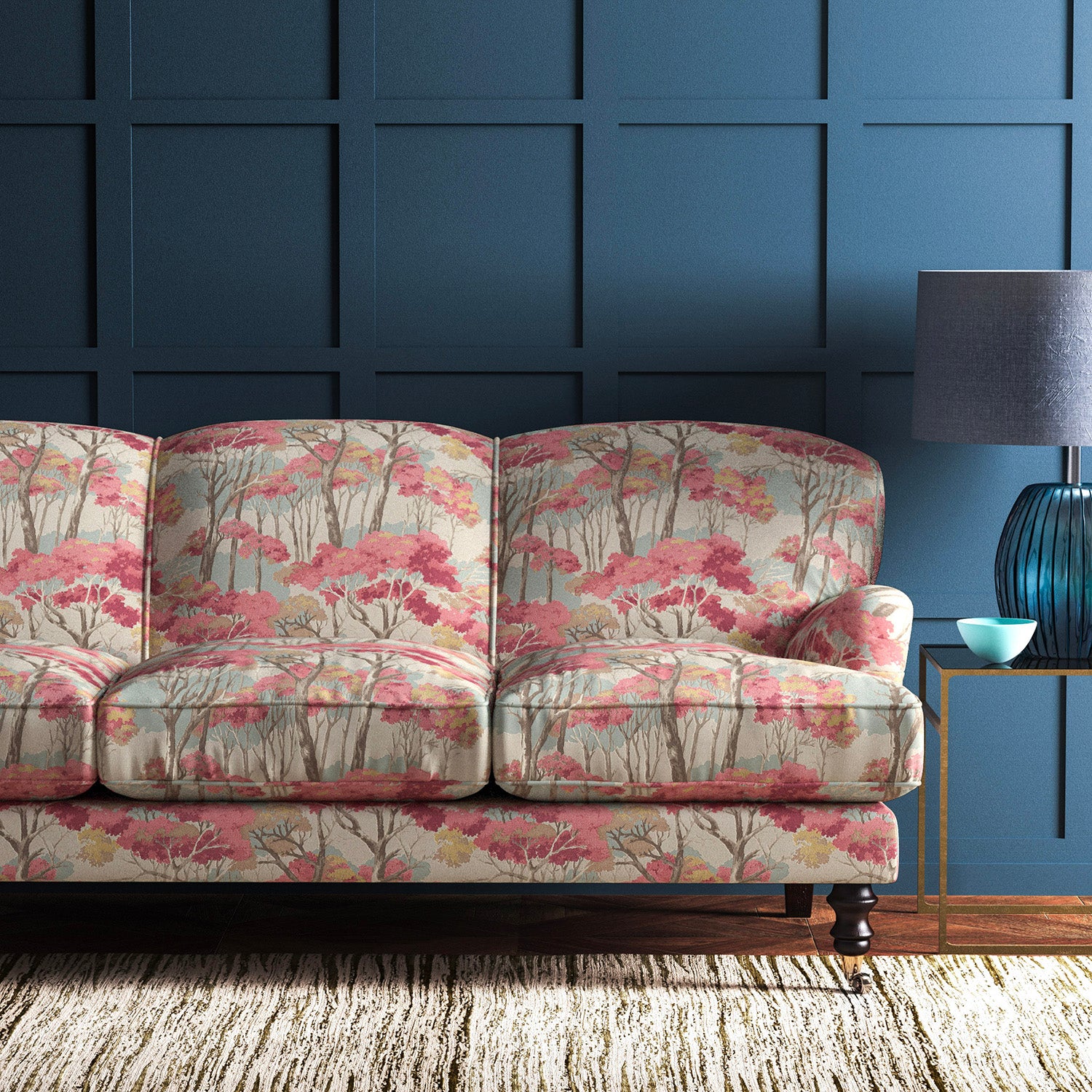 Sofa covered in a printed velvet upholstery fabric showcasing a pink Japanese tree design.