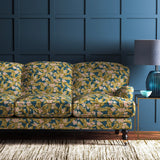 Sofa covered in a dark blue velvet upholstery fabric with ochre leaves and pretty flowers.