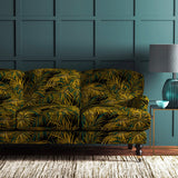 Sofa upholstered in green and gold printed velvet upholstery fabric with palm leaf design.
