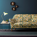 Sofa covered in a dark blue velvet upholstery fabric with ochre leaves and pretty flowers.