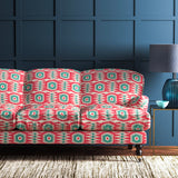 Sofa covered in a printed velvet upholstery fabric featuring a fun, jazzy pattern in Mandarin Orange. 