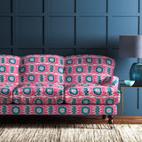 Sofa covered in a printed velvet upholstery fabric featuring a fun, jazzy pattern in Candy Pink. 