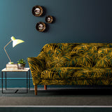 Sofa upholstered in green and gold printed velvet upholstery fabric with palm leaf design.
