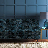Sofa upholstered in a grey/blue printed velvet upholstery fabric with palm leaf design.