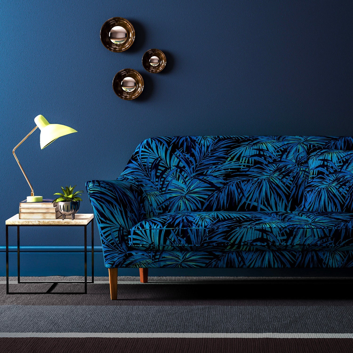 Sofa upholstered in an electric blue printed velvet upholstery fabric with palm leaf design. 