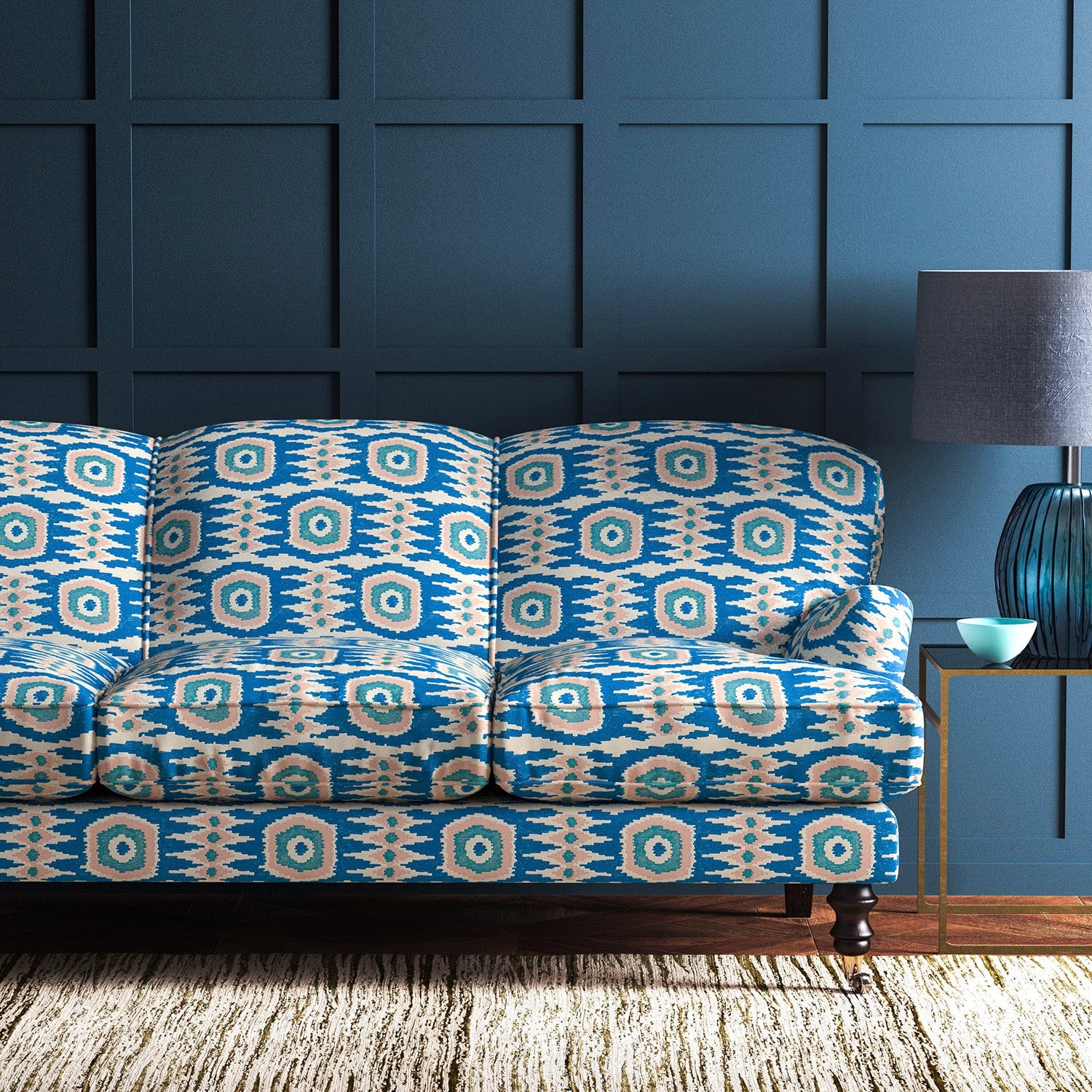 Sofa covered in a printed velvet upholstery fabric featuring a fun, jazzy pattern in blue, green and pink.