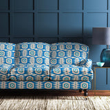 Sofa covered in a printed velvet upholstery fabric featuring a fun, jazzy pattern in blue, green and pink.