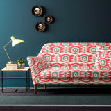 Sofa covered in a printed velvet upholstery fabric featuring a fun, jazzy pattern in Mandarin Orange. 